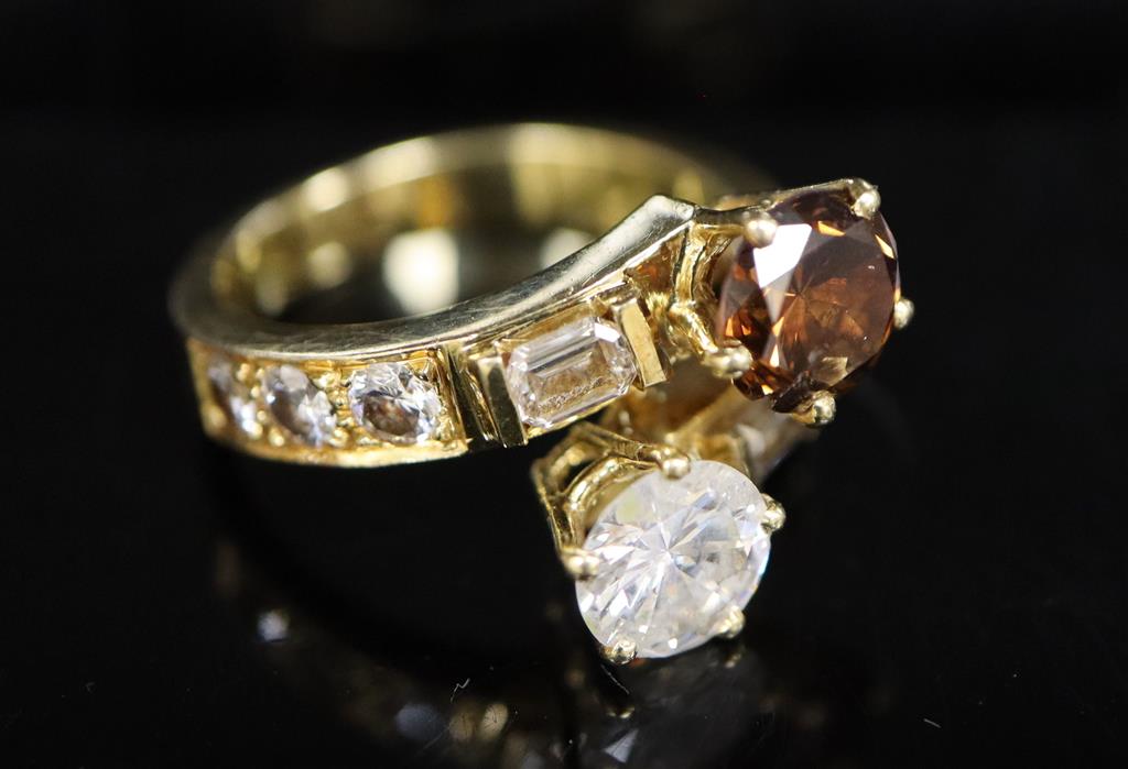 A modern yellow metal and two colour diamond two stone crossover ring,